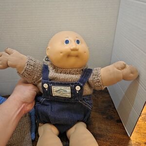 vintage Cabbage Patch Kids doll, specifically a bald boy model with blue eyes